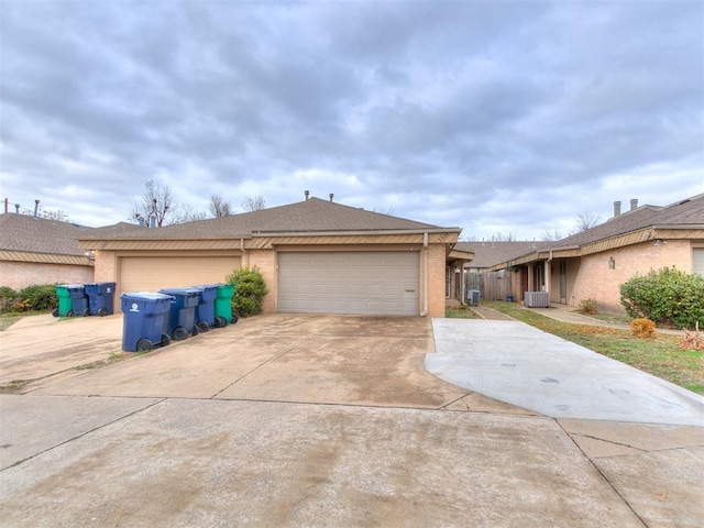 view of front of home with central AC unit and a garage