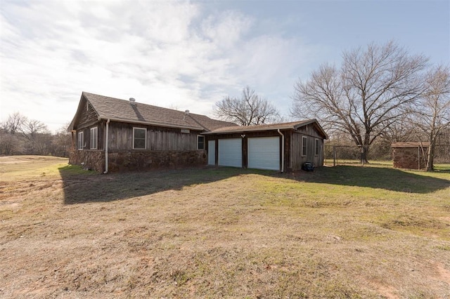 exterior space featuring a garage, an outbuilding, and a yard