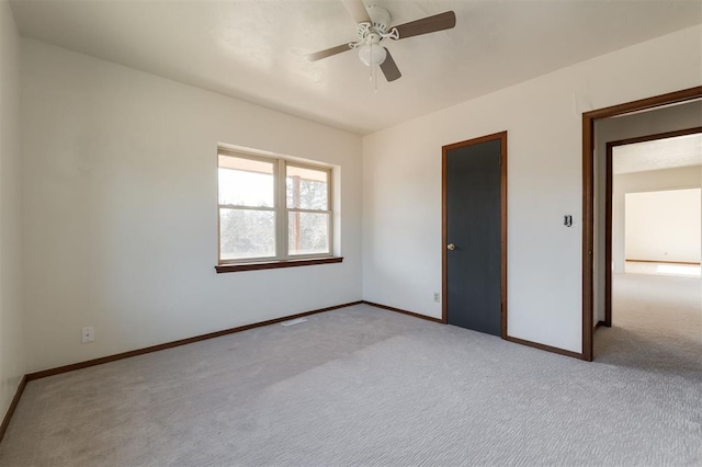 unfurnished bedroom with a closet, light colored carpet, and ceiling fan