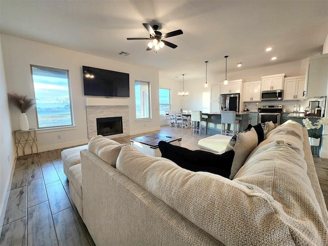 living room featuring a fireplace and ceiling fan