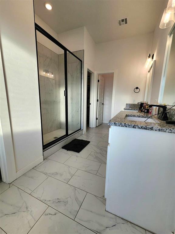 bathroom featuring vanity and an enclosed shower