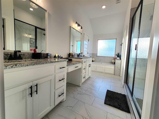 bathroom featuring vanity, vaulted ceiling, and independent shower and bath