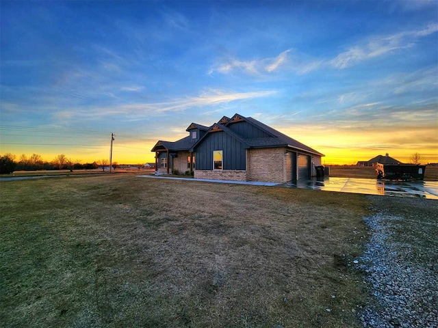 property exterior at dusk featuring a lawn and a garage