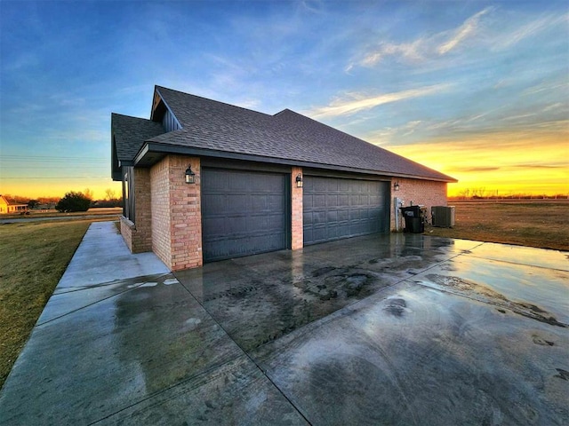 property exterior at dusk featuring cooling unit and a garage