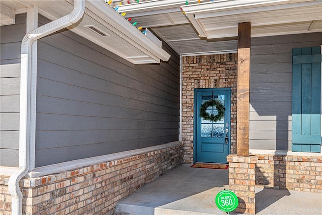 view of exterior entry featuring covered porch