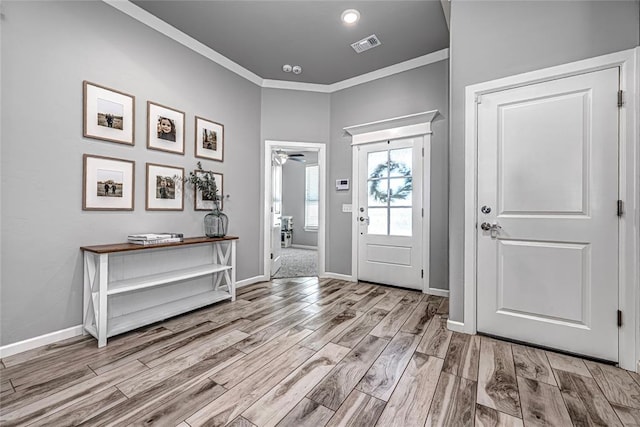 entrance foyer featuring ceiling fan, light wood-type flooring, and ornamental molding