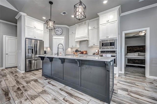 kitchen featuring premium range hood, white cabinetry, pendant lighting, and stainless steel appliances