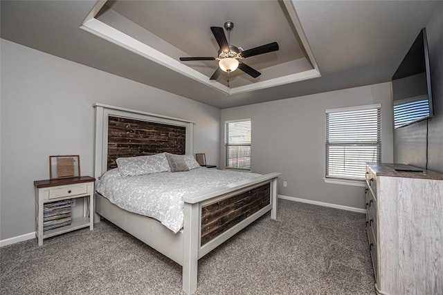 bedroom featuring a raised ceiling, ceiling fan, and carpet