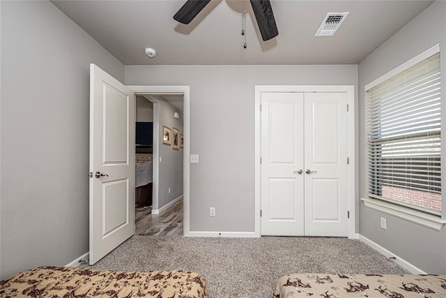 unfurnished bedroom featuring ceiling fan, a closet, and carpet