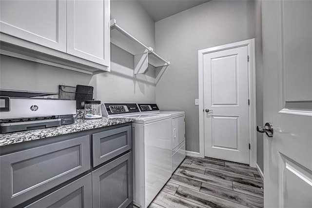 washroom featuring washing machine and dryer and light hardwood / wood-style flooring