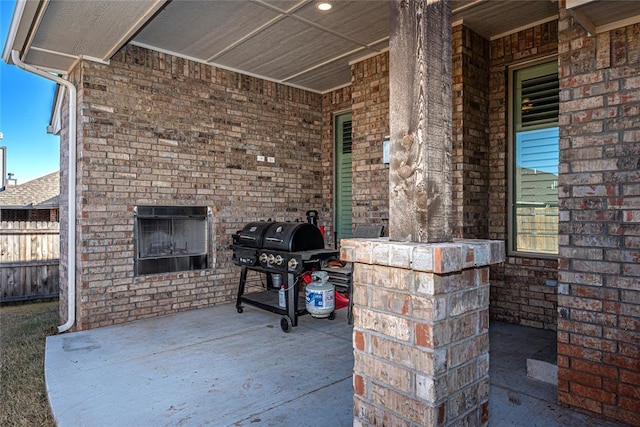 view of patio / terrace with grilling area and an outdoor brick fireplace