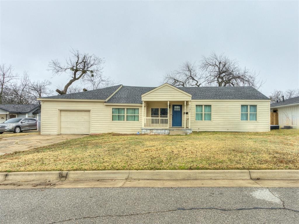 single story home featuring a front lawn, a porch, and a garage