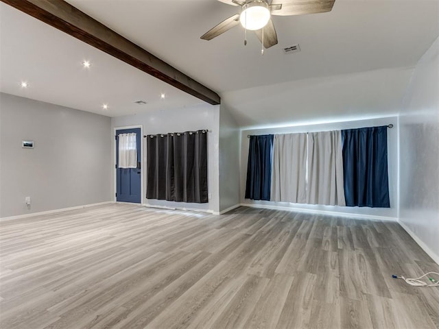 spare room with ceiling fan, beamed ceiling, and light wood-type flooring