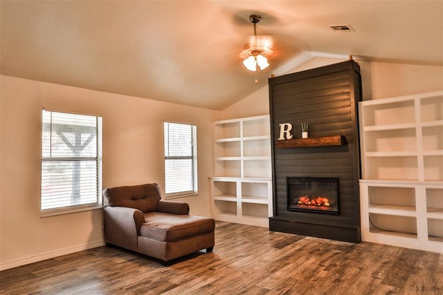 living area featuring a fireplace, hardwood / wood-style flooring, ceiling fan, and lofted ceiling