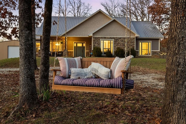 back house at dusk with an outbuilding, outdoor lounge area, and a garage