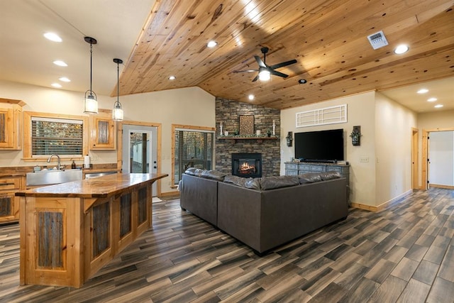 living room featuring ceiling fan, sink, dark hardwood / wood-style flooring, a fireplace, and wood ceiling