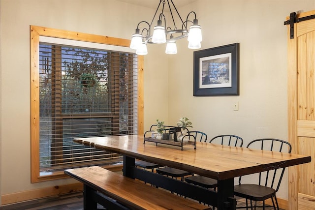 dining room with a chandelier, wood-type flooring, and a barn door