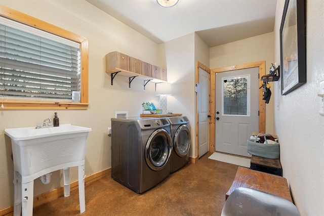 clothes washing area featuring washing machine and clothes dryer and sink