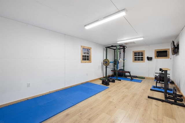 exercise area featuring a wall unit AC and wood-type flooring