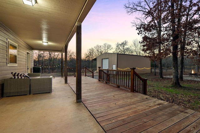 deck at dusk featuring a garage and an outdoor structure