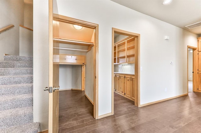 interior space featuring recessed lighting, visible vents, baseboards, stairway, and dark wood finished floors