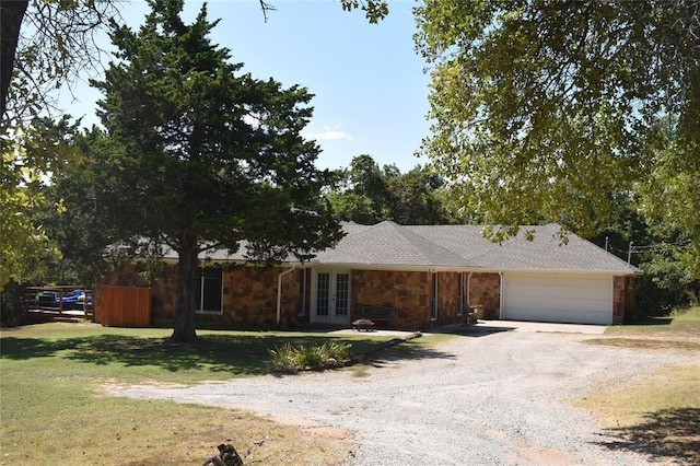 single story home with french doors, a front lawn, and a garage