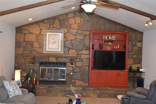 living room featuring a textured ceiling, vaulted ceiling with beams, a stone fireplace, and ceiling fan