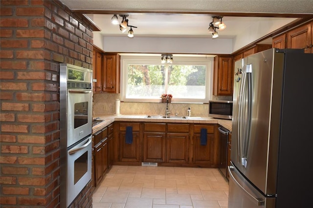 kitchen featuring stainless steel appliances, tasteful backsplash, and sink