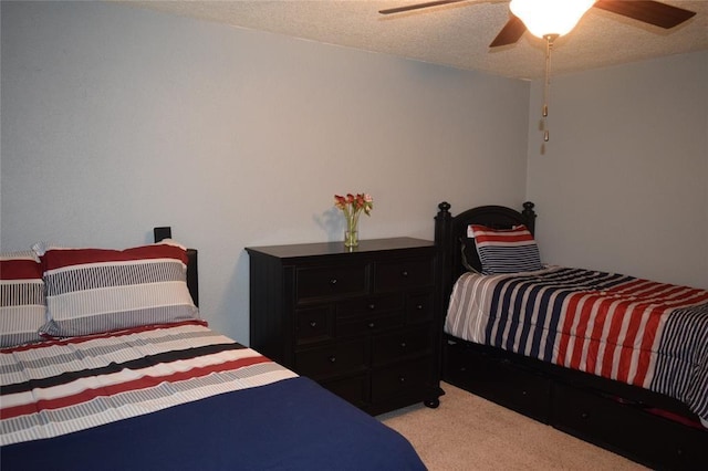 carpeted bedroom with ceiling fan and a textured ceiling