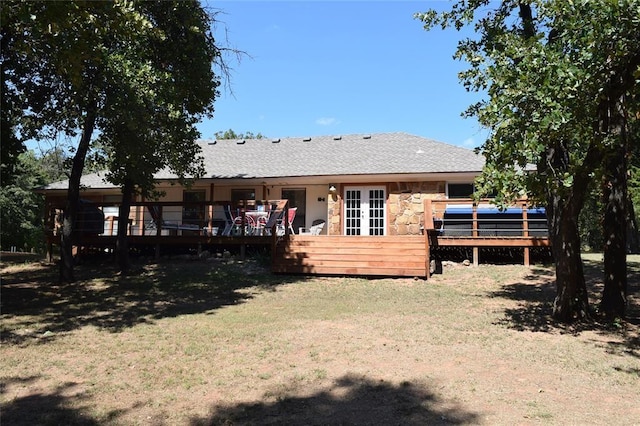 rear view of property with a yard and a wooden deck