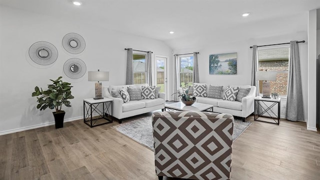 living room with light wood-type flooring and vaulted ceiling