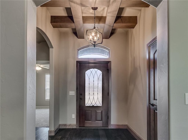 foyer entrance with ceiling fan with notable chandelier, beam ceiling, dark hardwood / wood-style flooring, and coffered ceiling