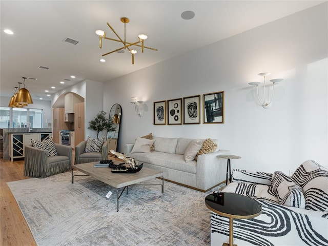 living room with sink, a chandelier, and hardwood / wood-style flooring