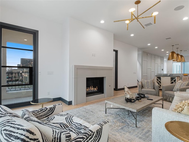 living room featuring an inviting chandelier and light hardwood / wood-style flooring