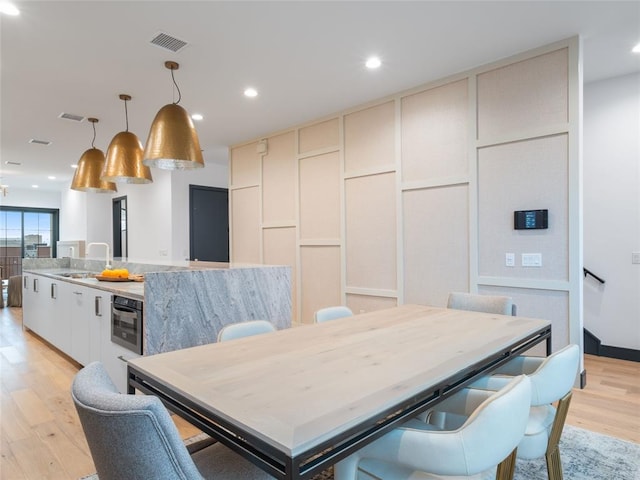 dining room with light hardwood / wood-style floors and sink