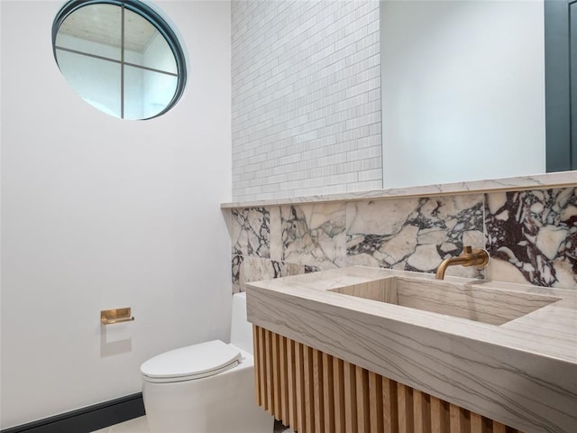 bathroom featuring decorative backsplash, vanity, and toilet