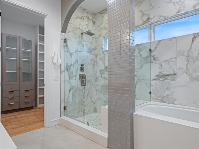 bathroom featuring hardwood / wood-style floors and plus walk in shower