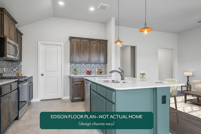 kitchen with decorative backsplash, stainless steel appliances, sink, pendant lighting, and an island with sink