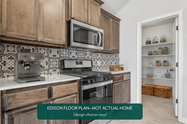 kitchen featuring backsplash, stainless steel appliances, and vaulted ceiling