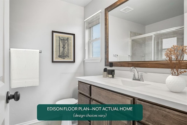 bathroom featuring a shower with door, vanity, and toilet