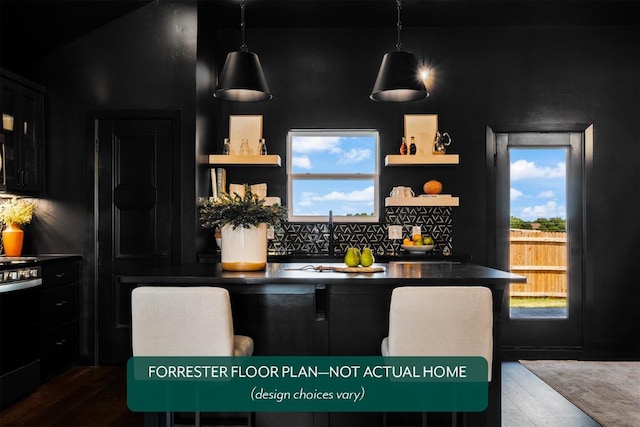 kitchen featuring pendant lighting, backsplash, black range, and a wealth of natural light