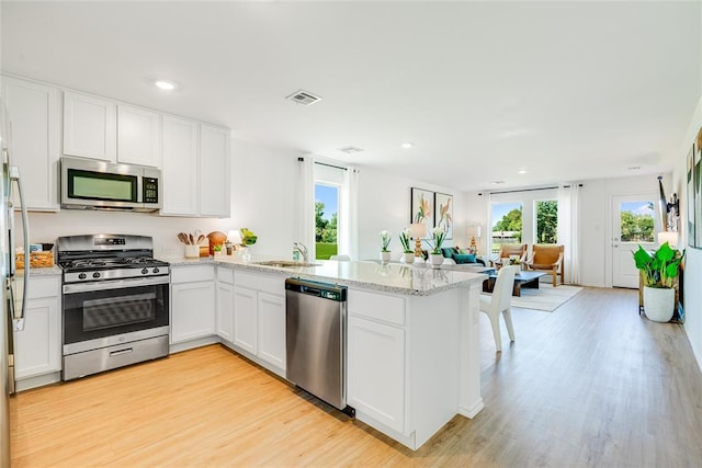 kitchen featuring white cabinetry, sink, kitchen peninsula, and stainless steel appliances