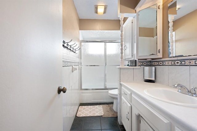 full bathroom featuring backsplash, vanity, shower / bath combination with glass door, tile patterned flooring, and toilet