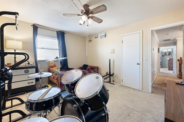 rec room with ceiling fan, light colored carpet, and a textured ceiling
