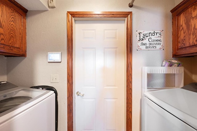 washroom with cabinets and washer and clothes dryer