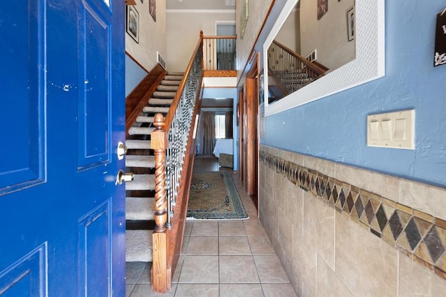 interior space with light tile patterned floors and tile walls