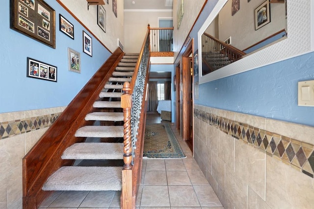 stairway featuring tile patterned floors and tile walls