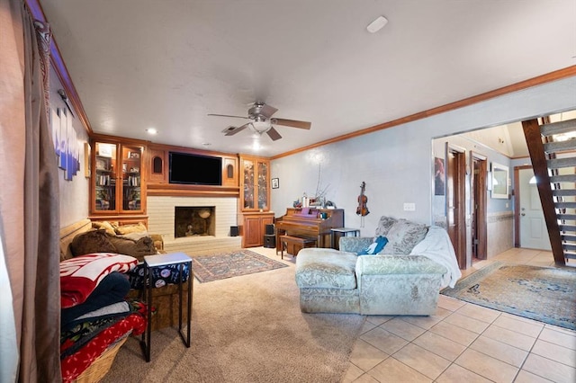 tiled living room featuring ceiling fan, a fireplace, and ornamental molding