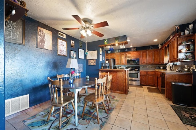 tiled dining space with ceiling fan, sink, and a textured ceiling