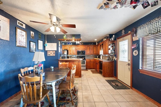 tiled dining room featuring a textured ceiling, ceiling fan, and sink